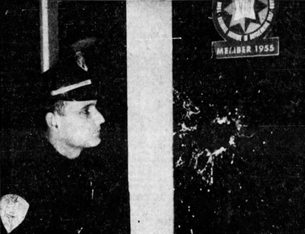 Paso Robles Police Officer Bud Requa examines a hole in the front window of the Paso Robles laundry where the capture of J. Thomas Caldwell, an ex-convict from Los Angeles, occurred on June 14, 1956. Lt. William Stonesifer of the Sheriff’s Department shot Caldwell in the hip when the fugitive leaped from behind one of the front windows with a .357 Magnum pistol.