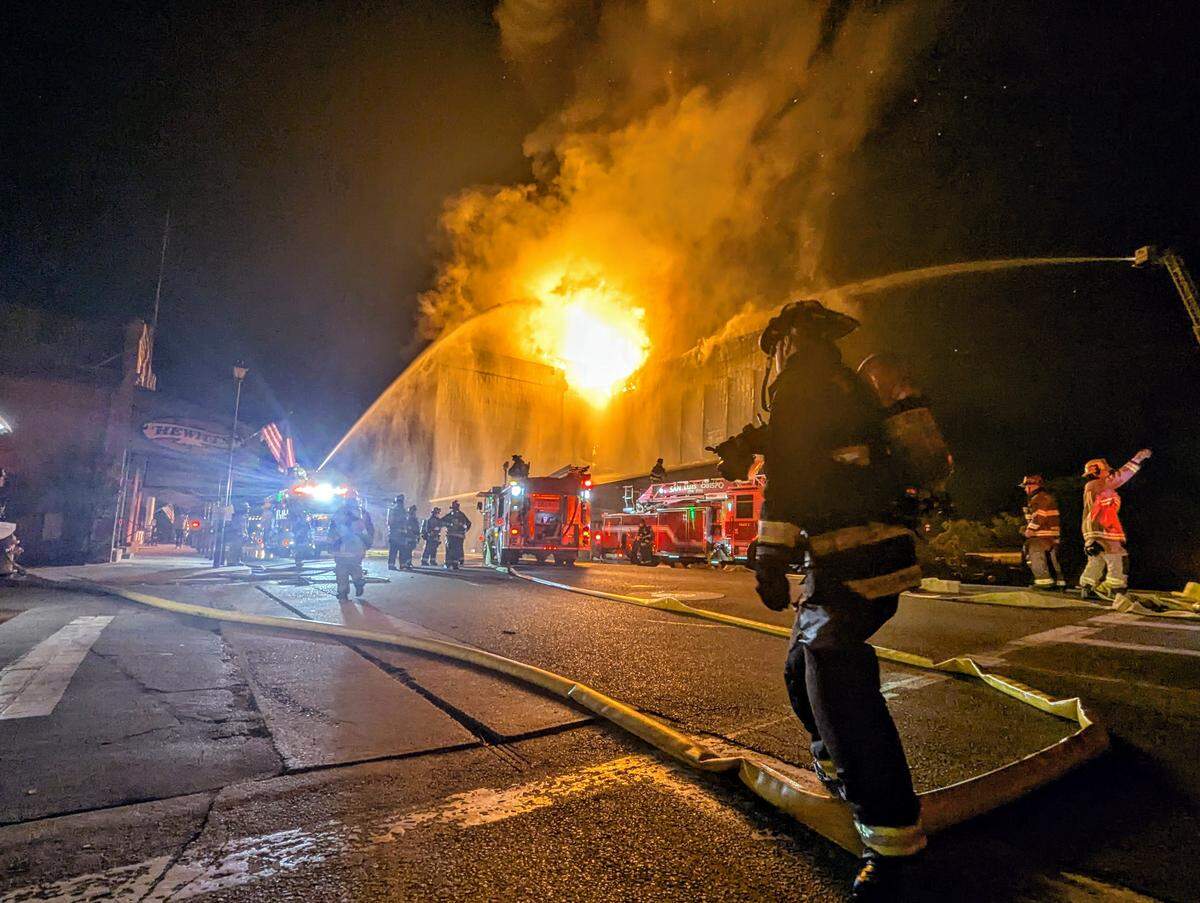 Firefighters spray water on the burning Templeton Feed and Grain building during a nighttime fire in downtown Templeton.