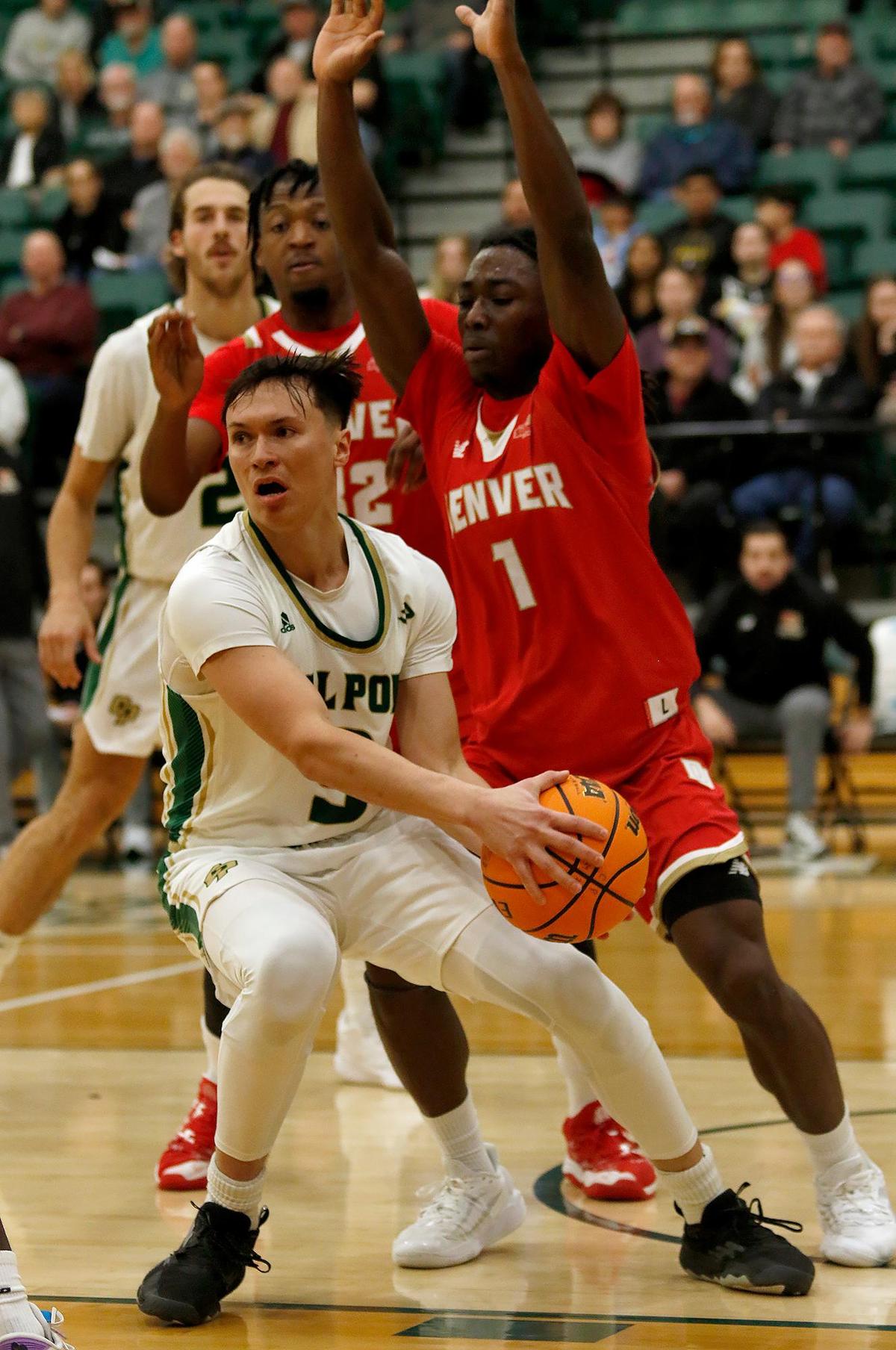 Cal Poly’s point guard Jarred Hyder passes the ball under pressure from Denver’s Nicholas Shogbonyo. Cal Poly Mustangs beat the Denver Pioneers 95-94 in overtime at Mott Athletic Center at Cal Poly’s San Luis Obispo campus, Tuesday, Dec. 17, 2024.