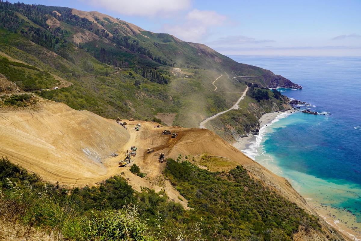 Dust rises from Regent’s Slide as Caltrans work teams clear debris from the slope, pictured Thursday, July 17, 2025. Regent’s Slide closed Highway 1 around 27 miles north of the San Luis Obispo-Monterey county line in February 2024.