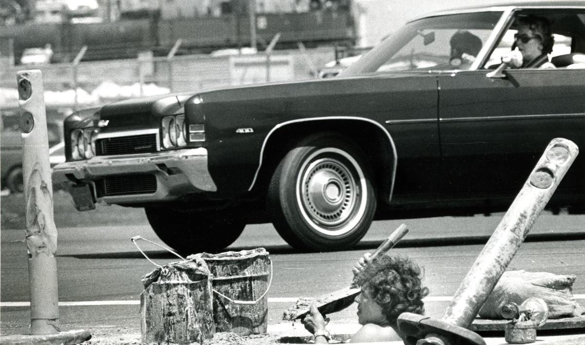 Construction worker Greg Leon was up to his neck in traffic Monday as he cleaned a storm drain on Broad Street in San Luis Obispo in August 1977.