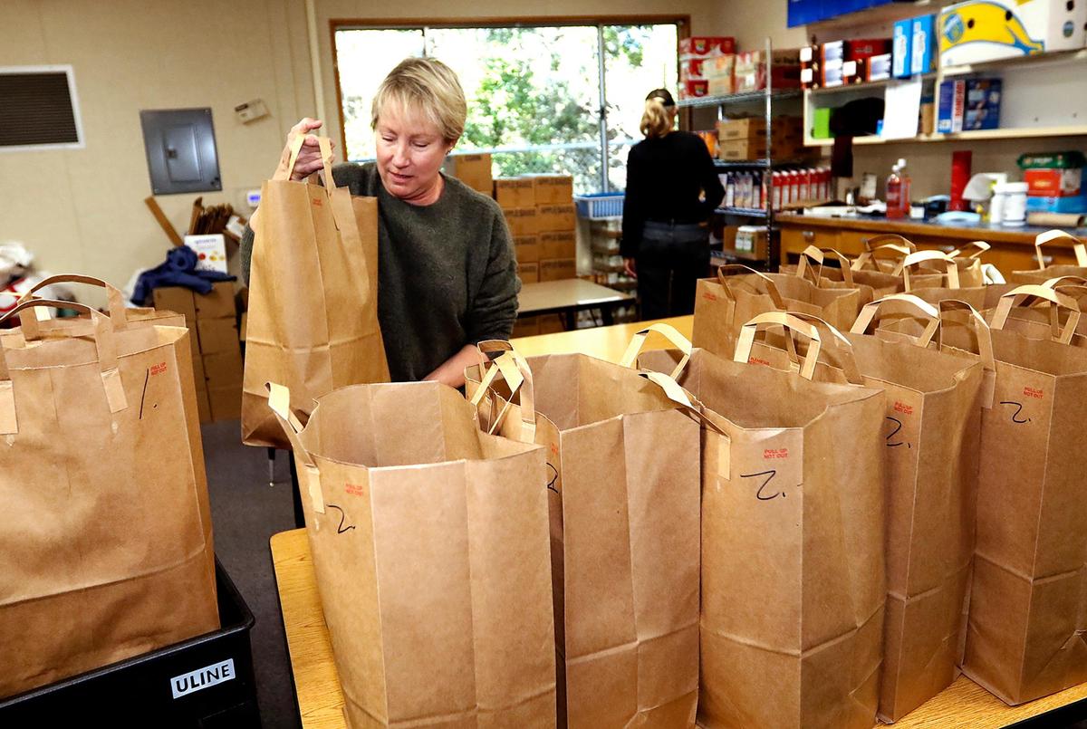 Kendra Clifton, a volunteer from Los Osos, helps pack bags with dry good.