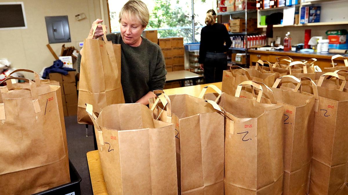 Kendra Clifton, a volunteer from Los Osos, helps pack bags with dry good.