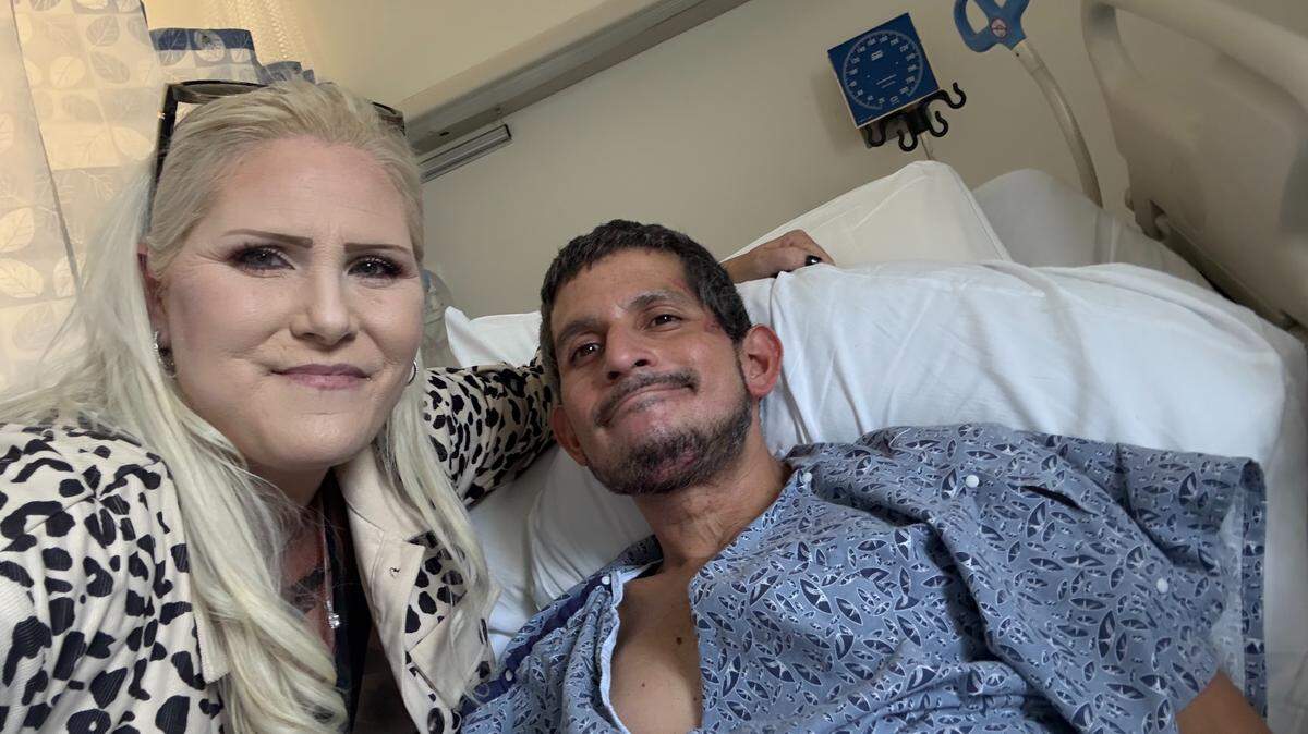 Grassroots homeless advocate Kimberlee Booth poses for a selfie with Adan Chavarria-Estrada in his Adventist Health Sierra Vista hospital bed after he was hit by a car in Paso Robles on Oct. 16, 2025. Chavarria-Estrada was enrolled in ECHO’s 90-day program but was hit by a car the day after he was kicked out of the program.