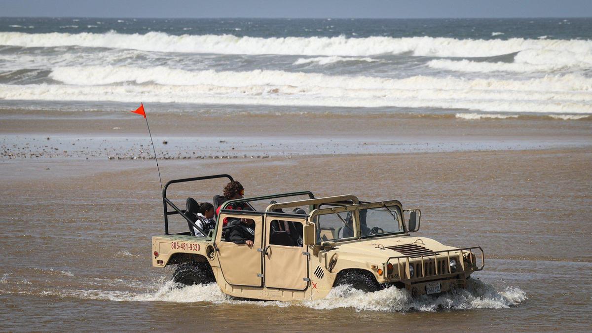 A hummer crosses Arroyo Grande Creek. High flow from Arroyo Grande Creek and high tides sweeping the beach have limited access to the Oceano Dunes to day use from 7 am to 2 pm.