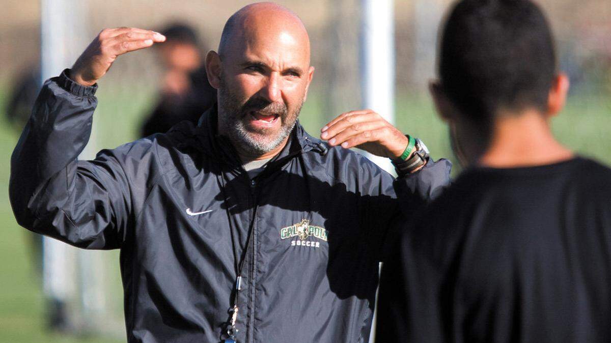 Paul Holocher shares instructions with his players while serving as head coach of the Cal Poly men’s soccer team in August 2013.