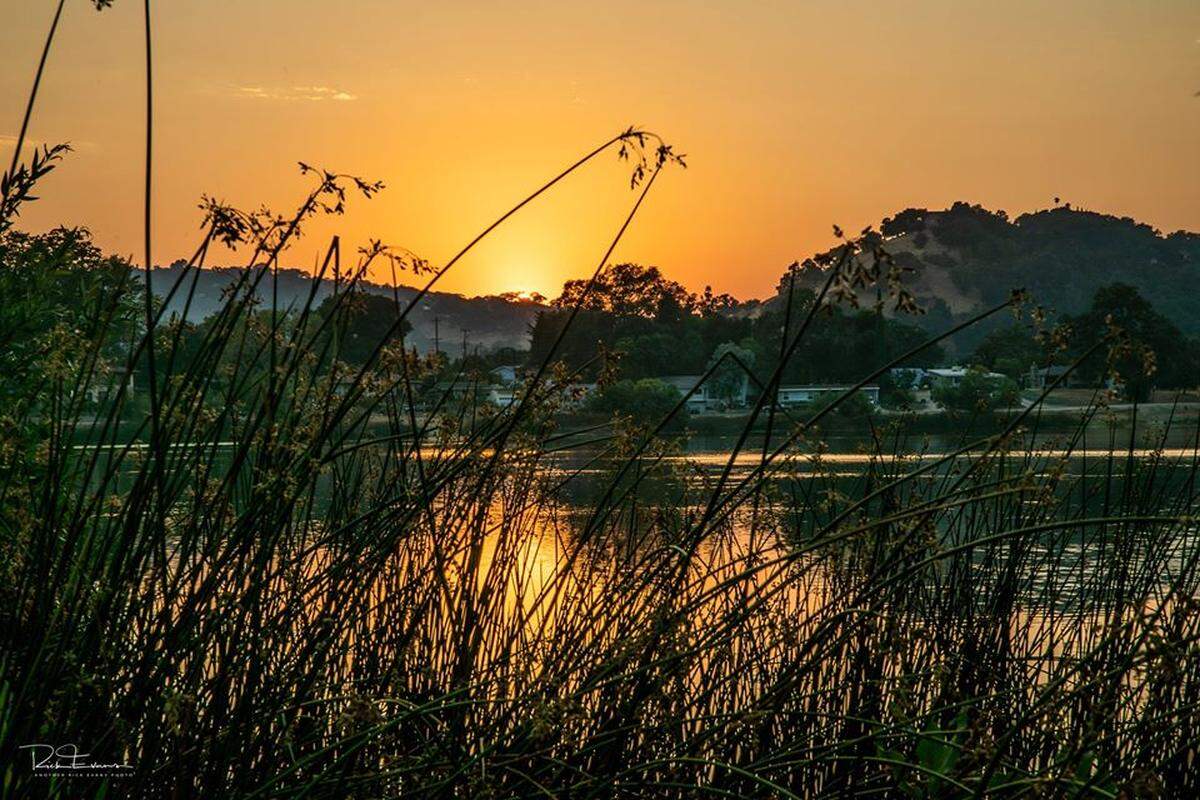 The first beginnings of smoke color the skies orange during an Atascadero Lake sunset on Monday, Aug. 17, 2020.