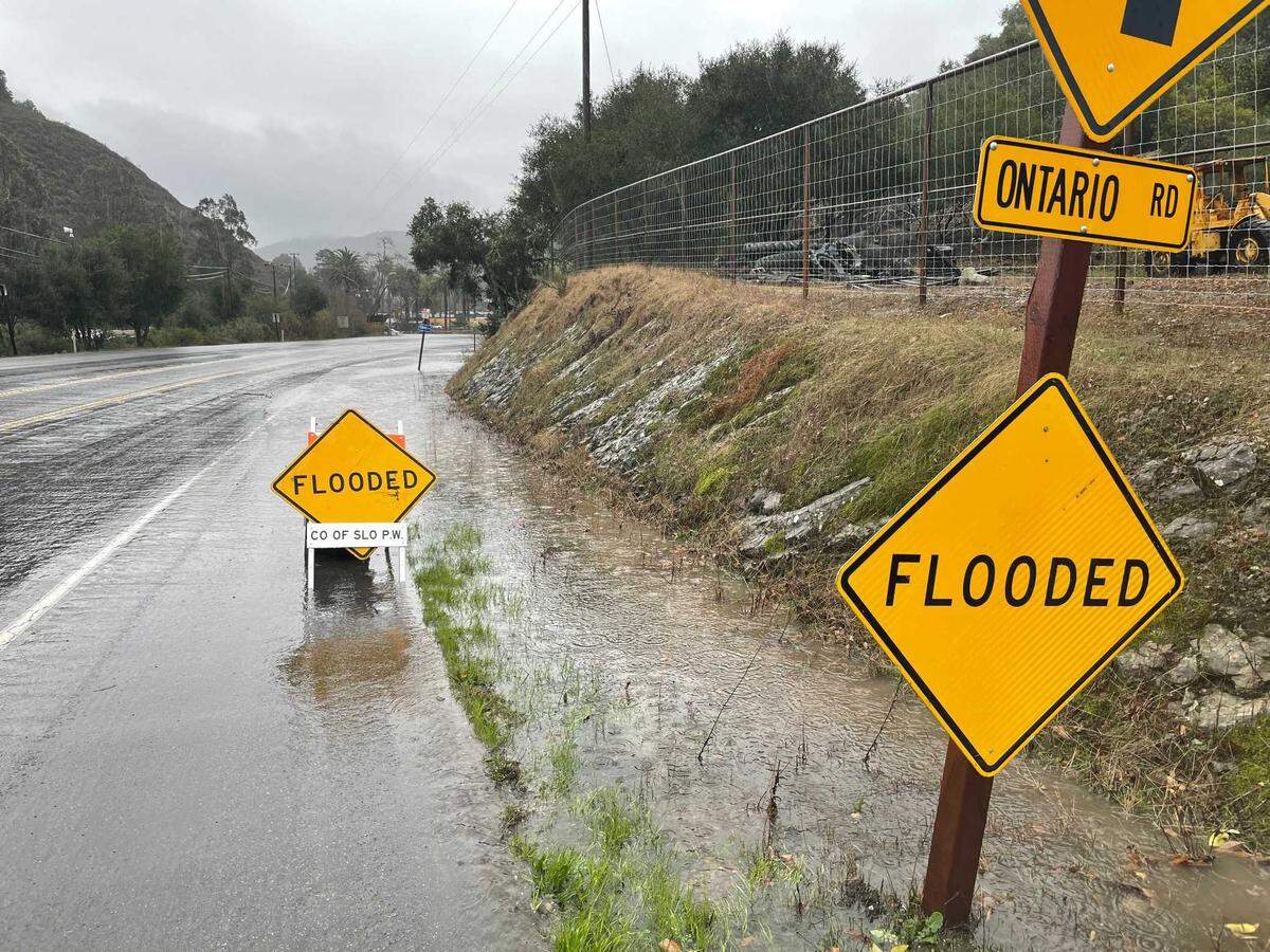 Signs warn drivers about a flooded section of Avila Beach Drive on Thursday.