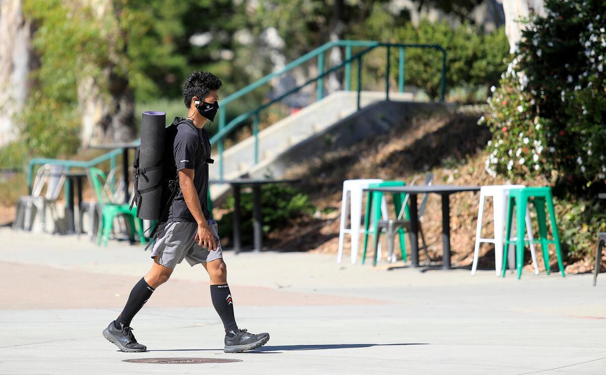 A masked student walks on Cal Poly’s campus in September 2020.