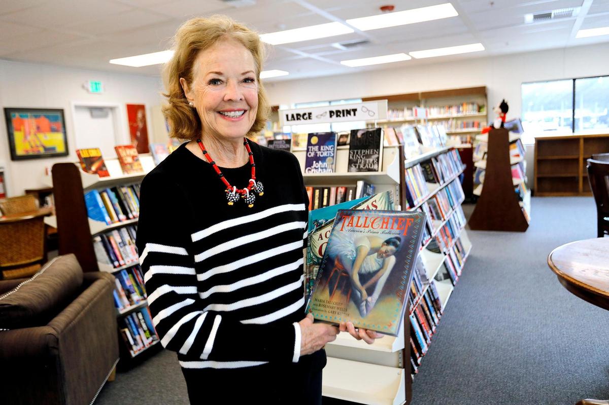Melinda Reid, Templeton Community Library Association president, holds up some of her favorite books at the new Templeton Library.