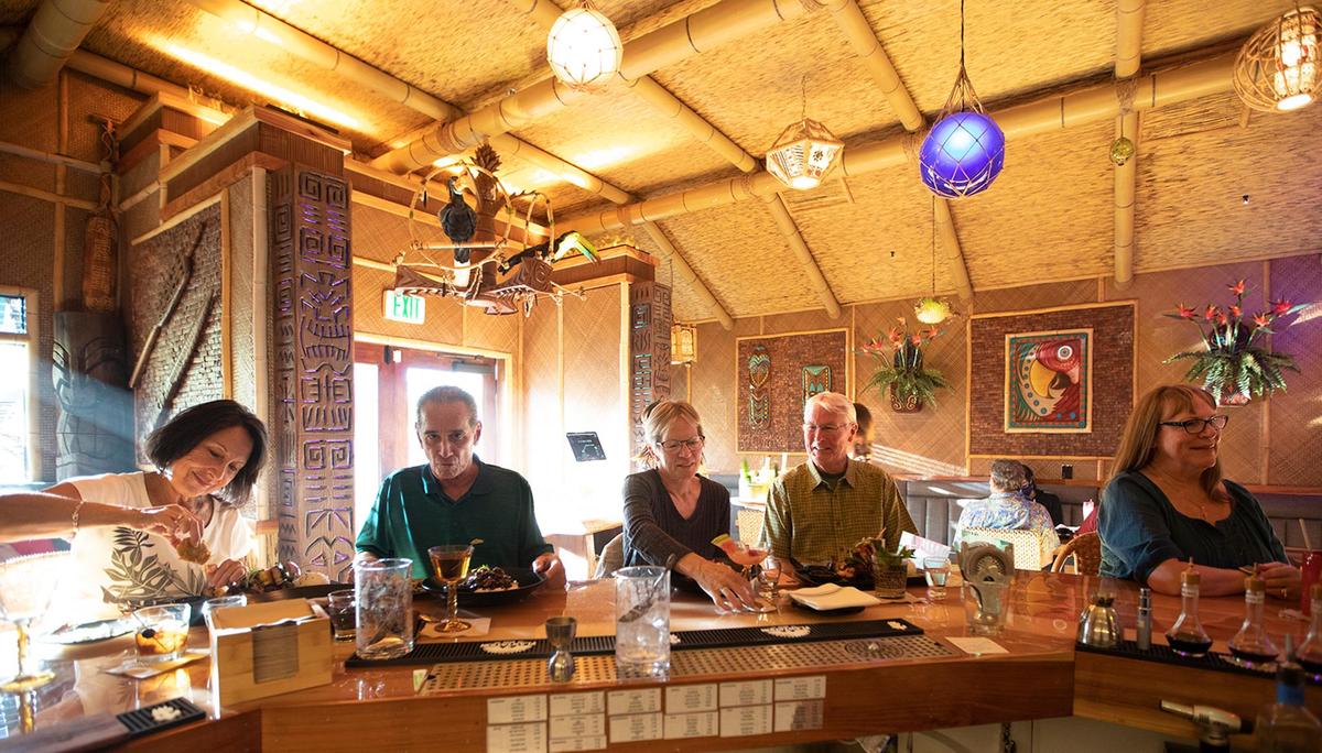 Visitors enjoy food and drinks at the Cane Tiki Room, the new tropical-themed bar and restaurant that opened in Paso Robles in February 2022.