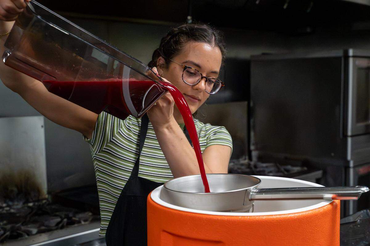 SLO Pressed owner Briana Medvecki pours a blend of fresh-pressed apple and lemon juice with a dash of beet in the kitchen at CaliPaso in San Luis Obispo on Thursday, May 14, 2026. Just one or two beets can color a batch of around 100 bottles of juice.