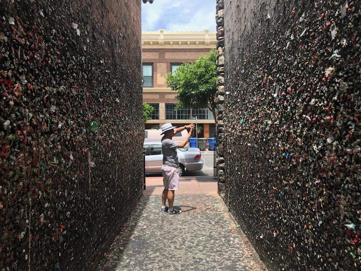 A tourist snaps the obligatory of Bubblegum Alley in downtown San Luis Obispo.