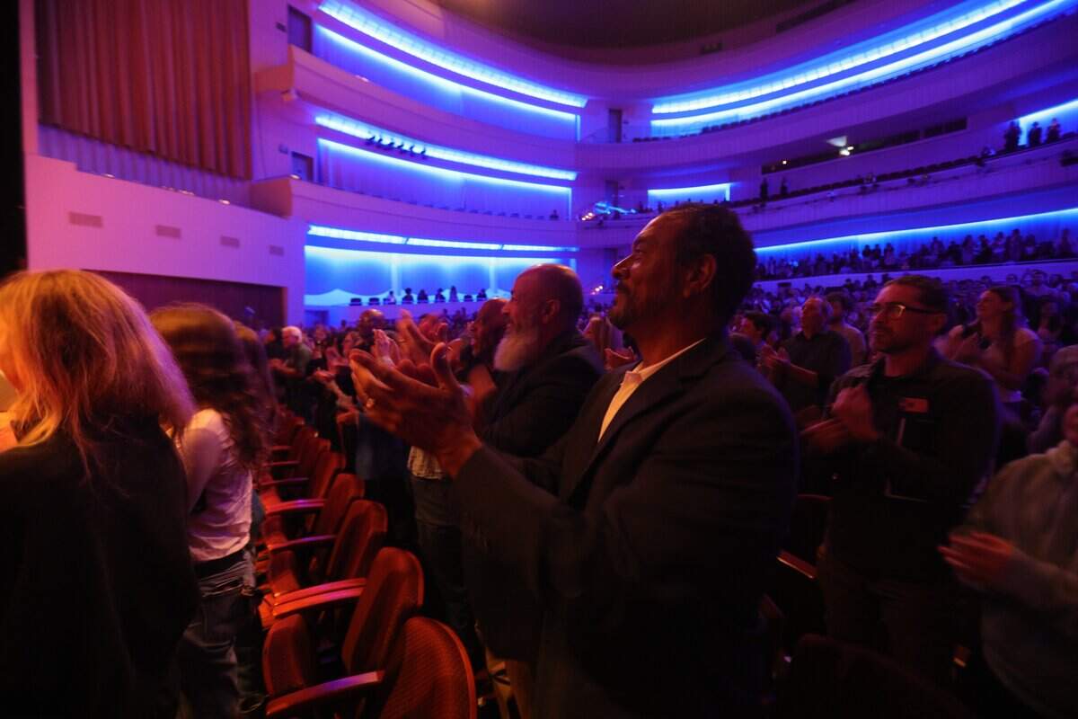 Members of the Phi Beta Sigma fraternity applaud in support of fellow member, NASA astronaut Victor J. Glover. They are, from left, Anthony Benning, Robert Megna and Leigh Cole. Glover was pilot of NASA's Artemis II mission to the moon in April 2026. The Cal Poly graduate spoke at the PAC on June 16, 2026.