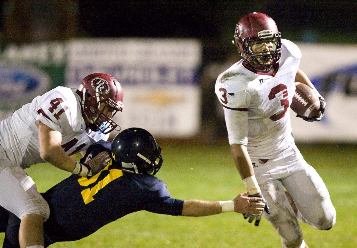 Paso Robles High’s Josh Oliver gets past Arroyo Grande’s Thomas Fuentez while Matt Keller blocks in 2014.