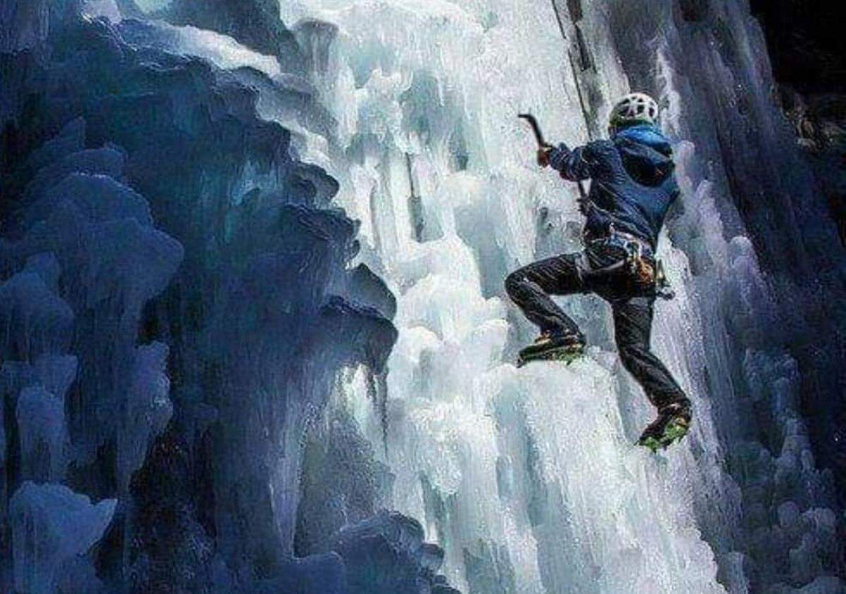 This screenshot shows a photo of extreme athlete Chance Ronemus climbing a frozen waterfall in Montana.