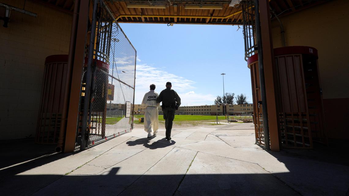 A correctional officer escorts an inmate at California Men’s Colony’s East Facility in San Luis Obispo. The prison is one of seven in the state to reach herd immunity for COVID-19 following severe outbreaks.