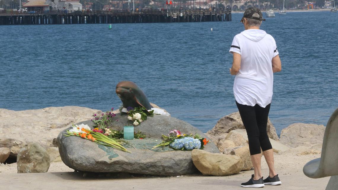 Sigrid Toye pauses Tuesday at a memorial dedicated to those lost at sea, at the end of the jetty in Santa Barbara. It’s been decorated with fresh flowers following Monday’s deadly dive boat fire.