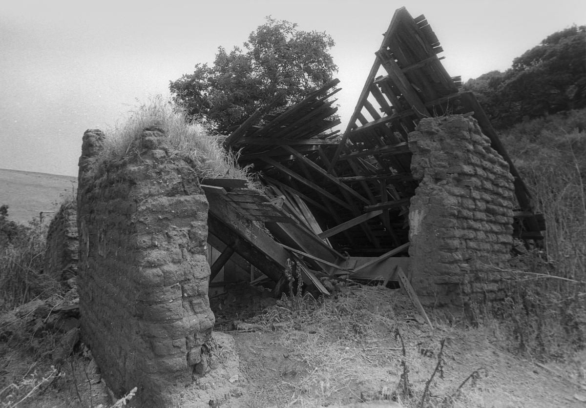 John Michael Price built a two-story adobe adjoining an existing, three-gabled adobe house in Pismo Beach. This adobe was well on the way to disintegration in September 1987.