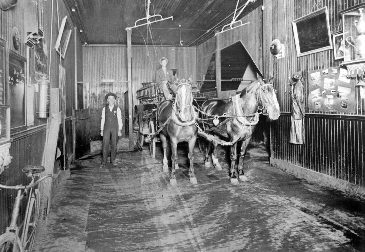 FIRE HOUSE INTERIOR - This was one side of the interior of the old Higuera Street San Luis Obispo city hall when it housed the fire department. Note the racks which held harness above the horses, ready for a quick hitch up. Centurama edition of the Telegram-Tribune.