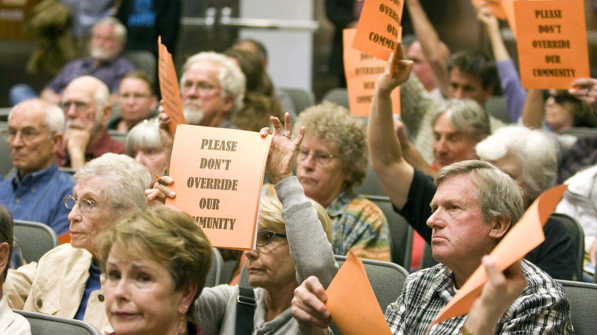Opponents of the quarry project hold signs in support of a speaker during the San Luis Obispo County Planning Commission meeting Thursday, Feb. 5, 2015.