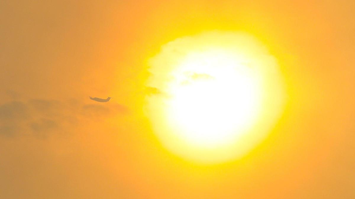 An air tanker flies by a smoke shrouded sun. A wind driven brush fire quickly moved south along Highway 101 along the Shell Beach straits and into Pismo Beach.