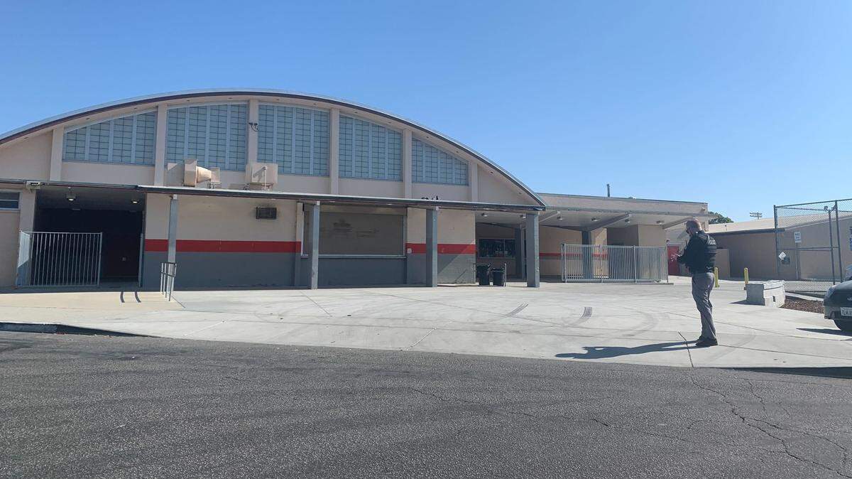 An Atascadero Police Department officer stands outside the gym at the back of Atascadero High School on Thursday, May 26, 2022. The school was evacuated due to a safety threat.