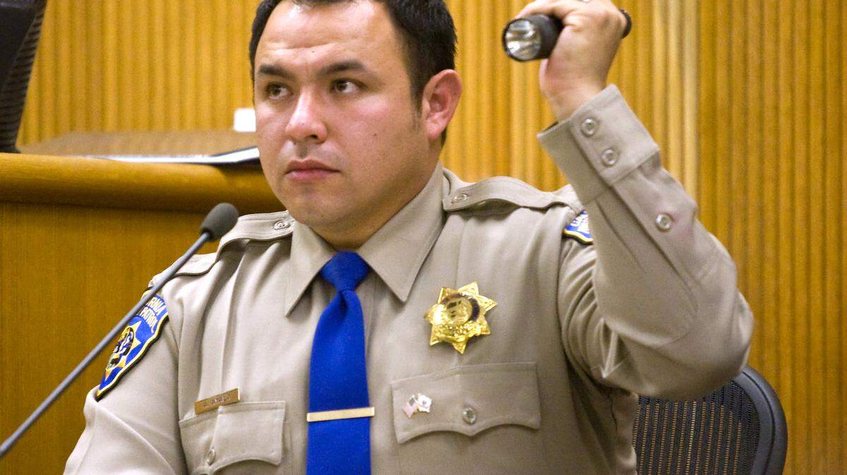 CHP Officer Adrian Ayala demonstrates in court Thursday, Jan. 9, how he searched for a fugitive with a flashlight.