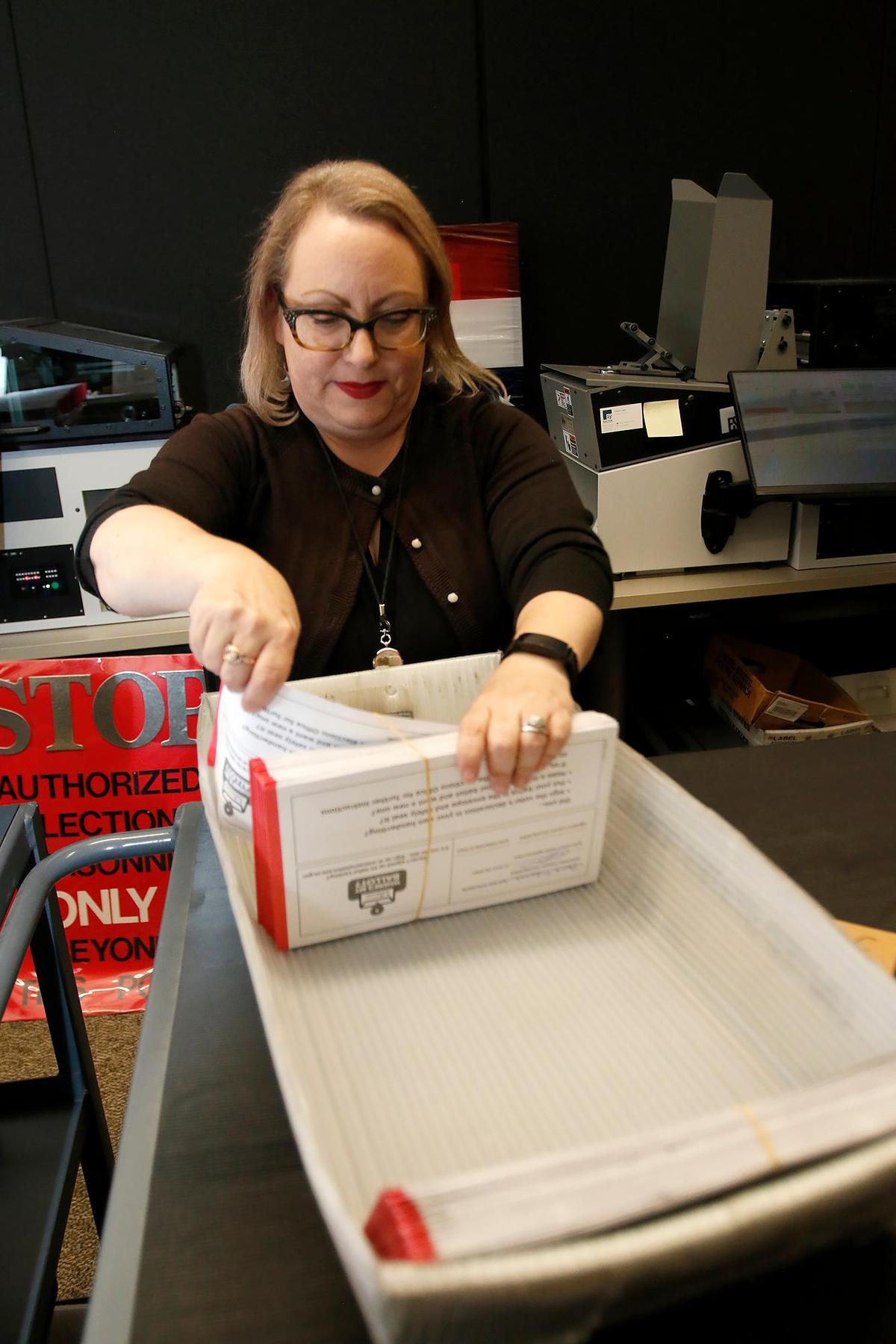 San Luis Obispo County Deputy Director Clerk-Recorder Melanie Foster processes vote-by-mail ballots for signature certification on Wednesday, Nov. 9, 2022. The San Luis Obispo County Elections Office will start counting ballots again on Friday, Nov. 11, and release more results that day.
