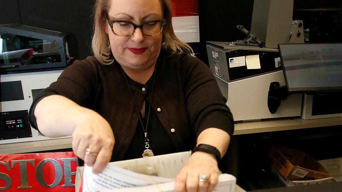 Deputy Director Clerk-Recorder Melanie Foster processes vote-by-mail ballots for signature certification on the day after the election, Nov. 9, 2022. The Elections Office will start counting ballots again on Friday and release another ballot count report that day at about 5 p.m.