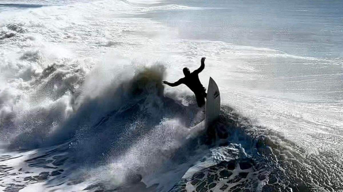 A surfer tackles king tide waves in Cayucos, California on Jan. 24, 2023.