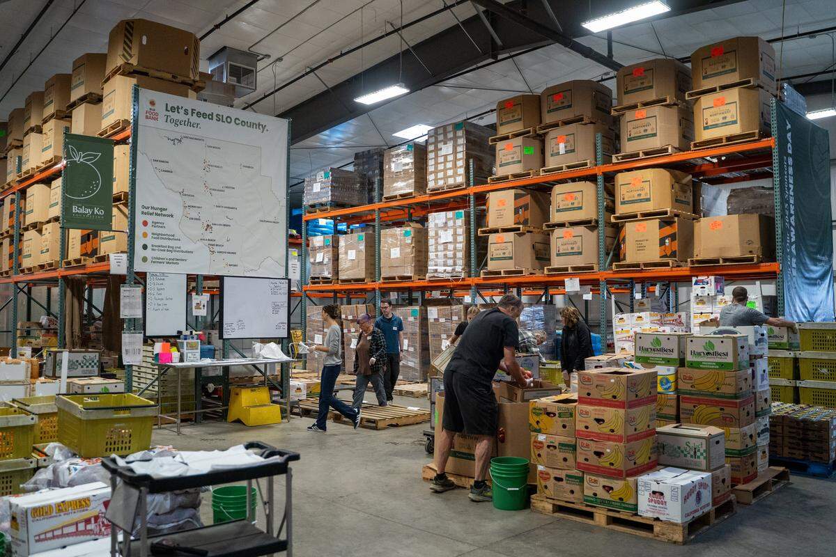 Volunteers begin sorting food into delivery boxed at the SLO Food Bank headquarters on Friday, Oct. 31, 2025. The SLO Food Bank is projecting a significant increase in demand for its services while the federal shutdown cuts off SNAP benefits.