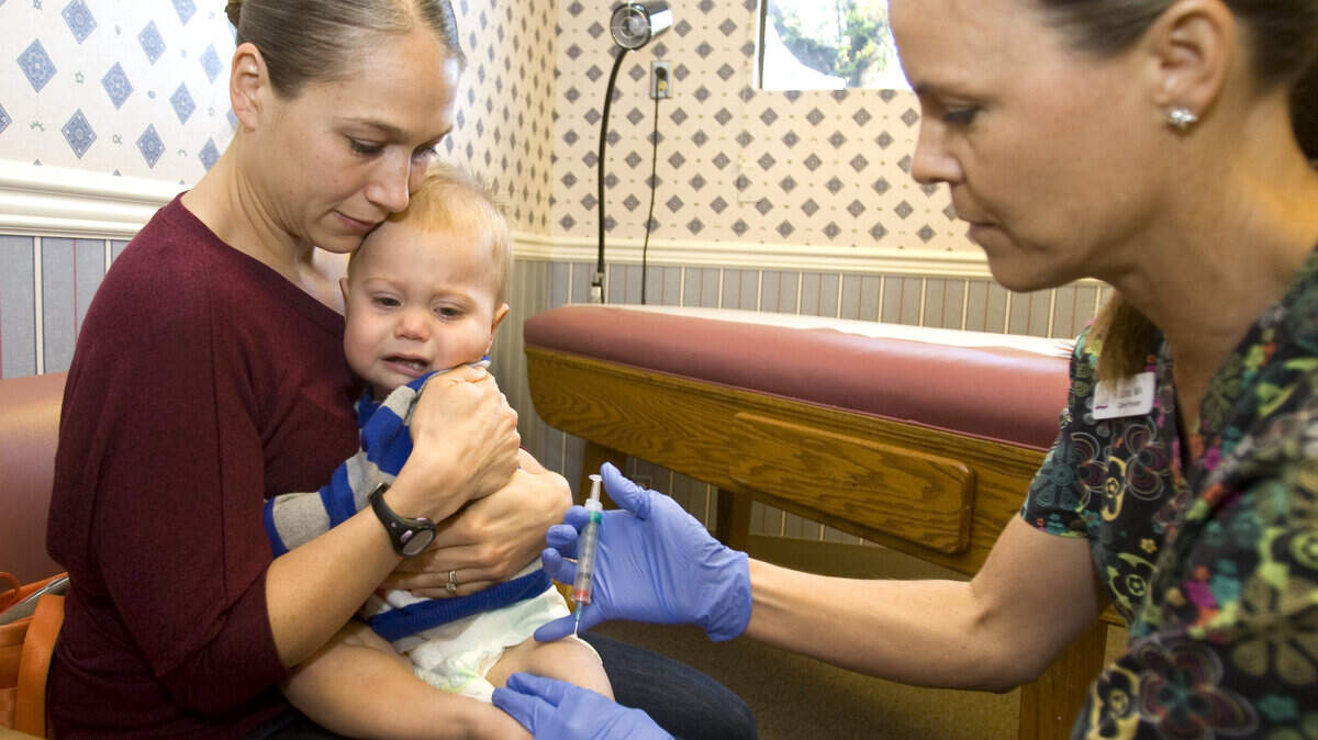 Medical Assistant Lora Torres administers a measles, mumps, rubella chicken pox vaccine to Brennan Perhach, 15 months, as he is held by his mom, Megan, at Patterson & Tedford Pediatrics in Atascadero.