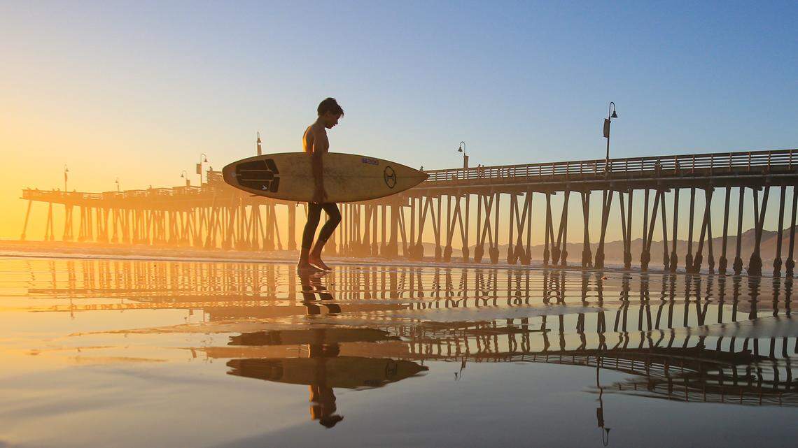 Cody Johnson, 13, returns to shore as the sun sets after an evening surf session near the Pismo Beach Pier on Monday, Nov. 16, 2020.