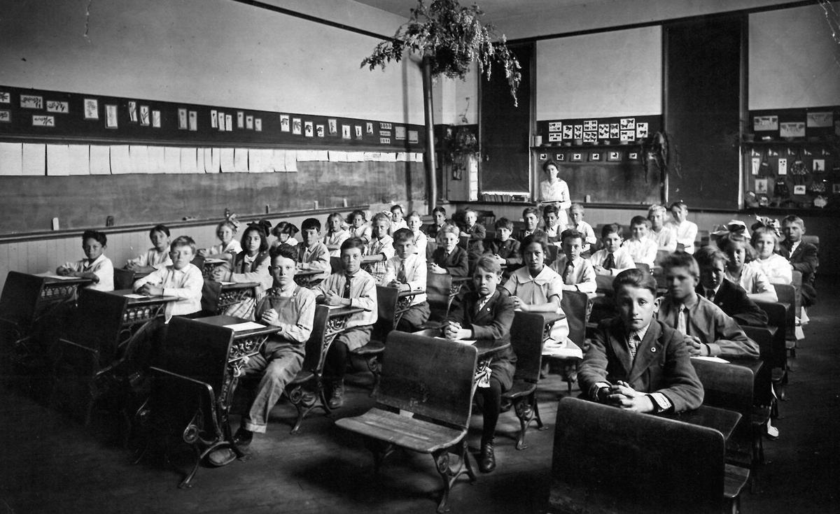 Mrs. Nicholson’s class at Emerson School in San Luis Obispo. About 35 students pose for a photo in an early 20th century classroom, in a room full of blackboards and folding desks.