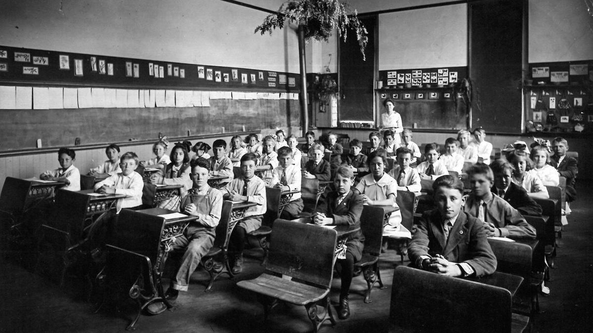 Mrs. Nicholson’s class at Emerson School in San Luis Obispo. About 35 students pose for a photo in an early 20th century classroom, in a room full of blackboards and folding desks.
