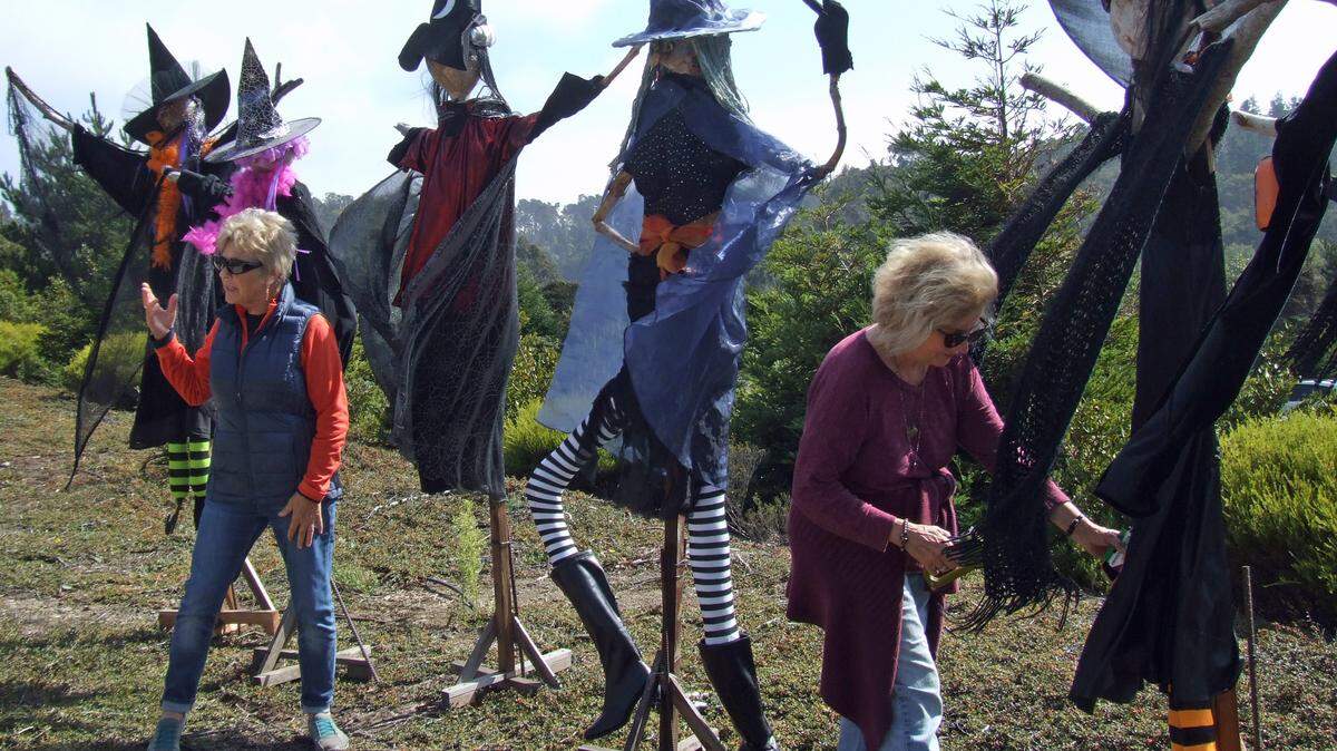 From left, Connie Brauer and Helen Pitton are among the volunteers putting finishing touches on their “A Woggle of Witches” scarecrows alongside Main Street near Santa Rosa Catholic Church and Rabobank.