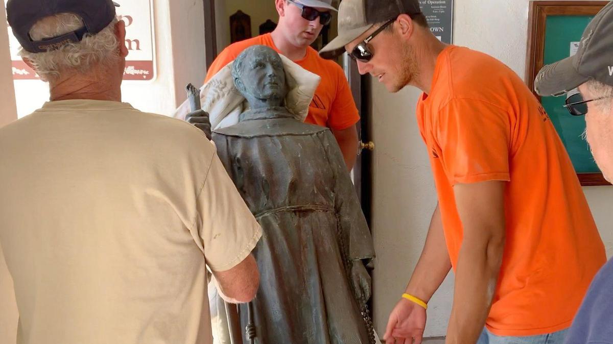 Workers remove the statue of Father Serra from its spot facing Mission Plaza in San Luis Obispo.