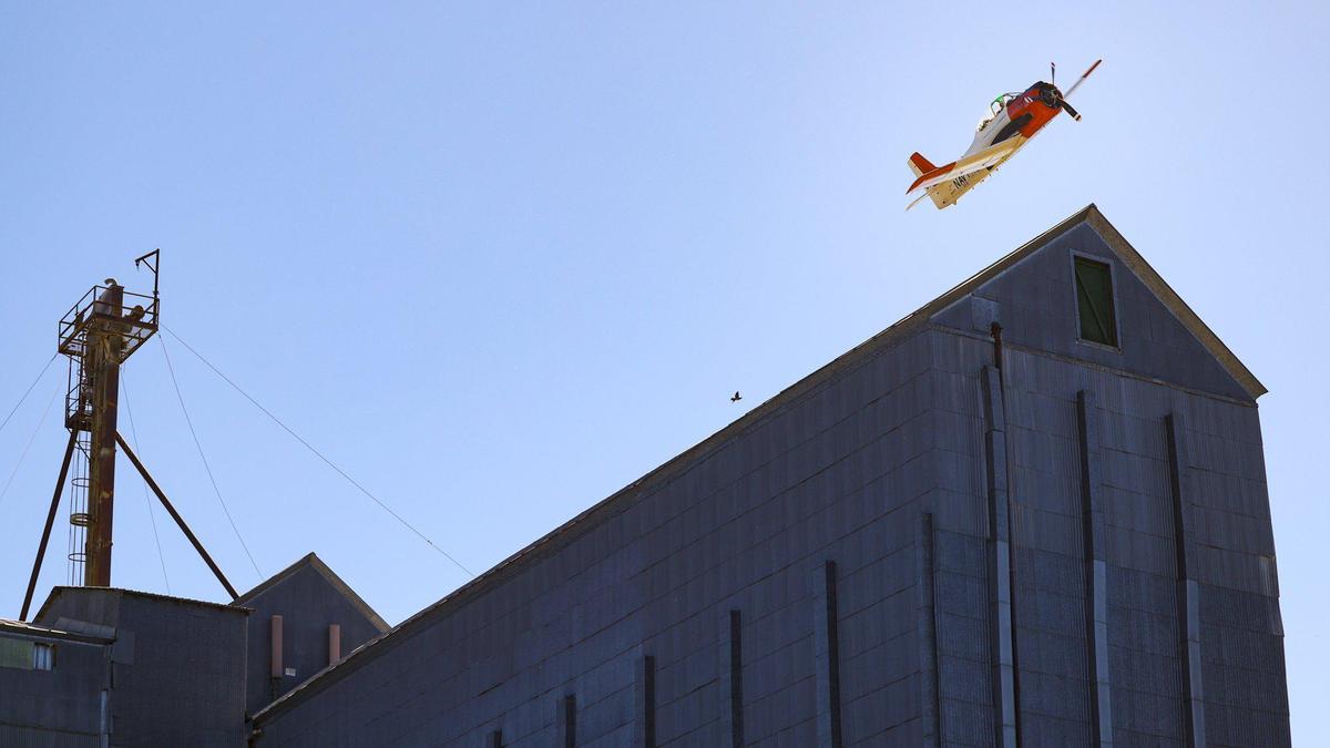 A T-28B Trojan training aircraft from Estrella Warbirds Museum in Paso Robles over the grain elevator during the Templeton 4th of July Parade on Tuesday, July 4, 2023.