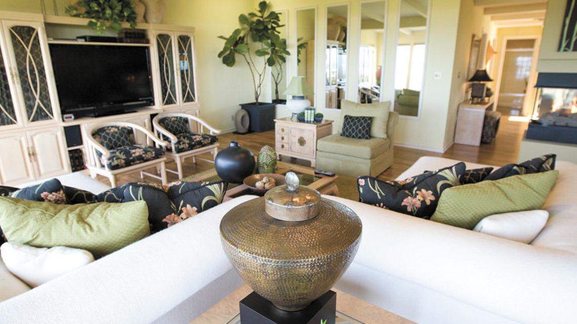The living room of Jean and Peter Herring's home was redecorated in a neutral color palette. A wall of windows reflects the ocean view.