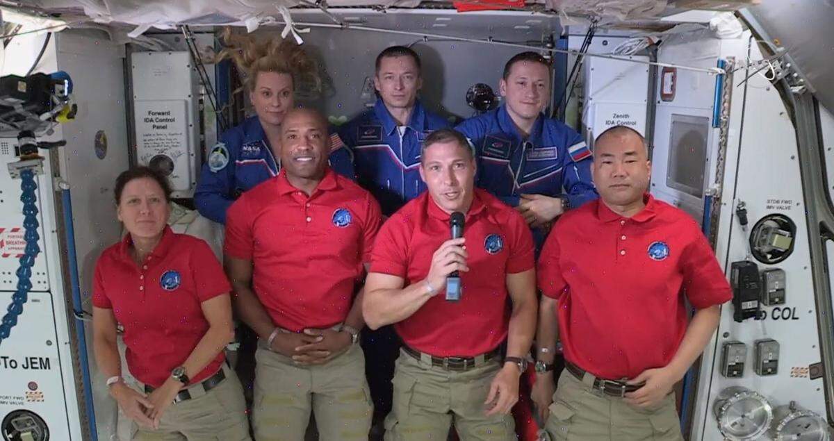 NASA astronaut Michael Hopkins speaks during a post-arrival news conference aboard the International Space Station. Top, from left to right: NASA astronaut Kate Rubins, and Russian cosmonauts Sergey Ryxhikov and Sergey Kud-Sverchkov. Bottom, from left to right: NASA astronauts Shannon Walker, Victor Glover, Hopkins, and Japanese astronaut Soichi Noguchi.