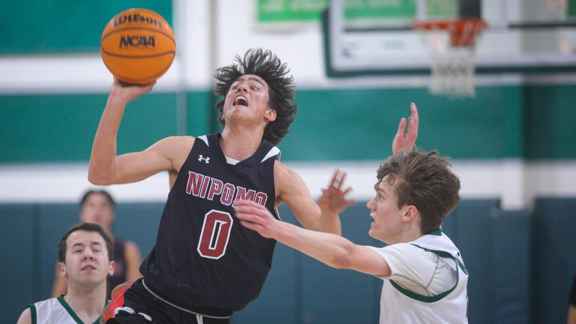 Lucca Hart is fouled by Maddox Watson while taking a three-point shot in Nipomo’s 74-60 win over Templeton in a boys basketball game in Templeton on Feb. 1, 2023. Hart scored 38 points to lead the Titans.