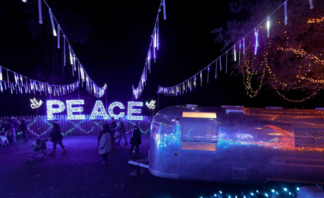 A lighted “Peace” sign is reflected by the shining exterior of a Streamline trailer serving as photo booth at the Cambria Christmas Market on Wednesday, Dec. 14, 2022.