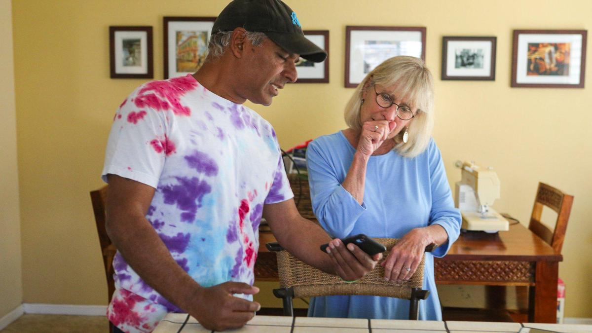 Bonnie Ernst, had been renting out her Oceano home for AirBnB and Arul Teimouri was a guest since before the shelter in place order so they decided to continue. Arul shows Bonnie a picture on phone from a recent walk at the beach. 5-6-2020