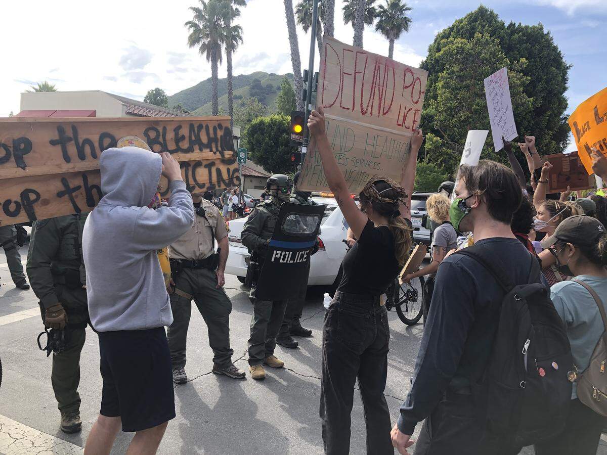 Protesters face off with a police blockade as the march attempts to make its way further down Higuera Street.