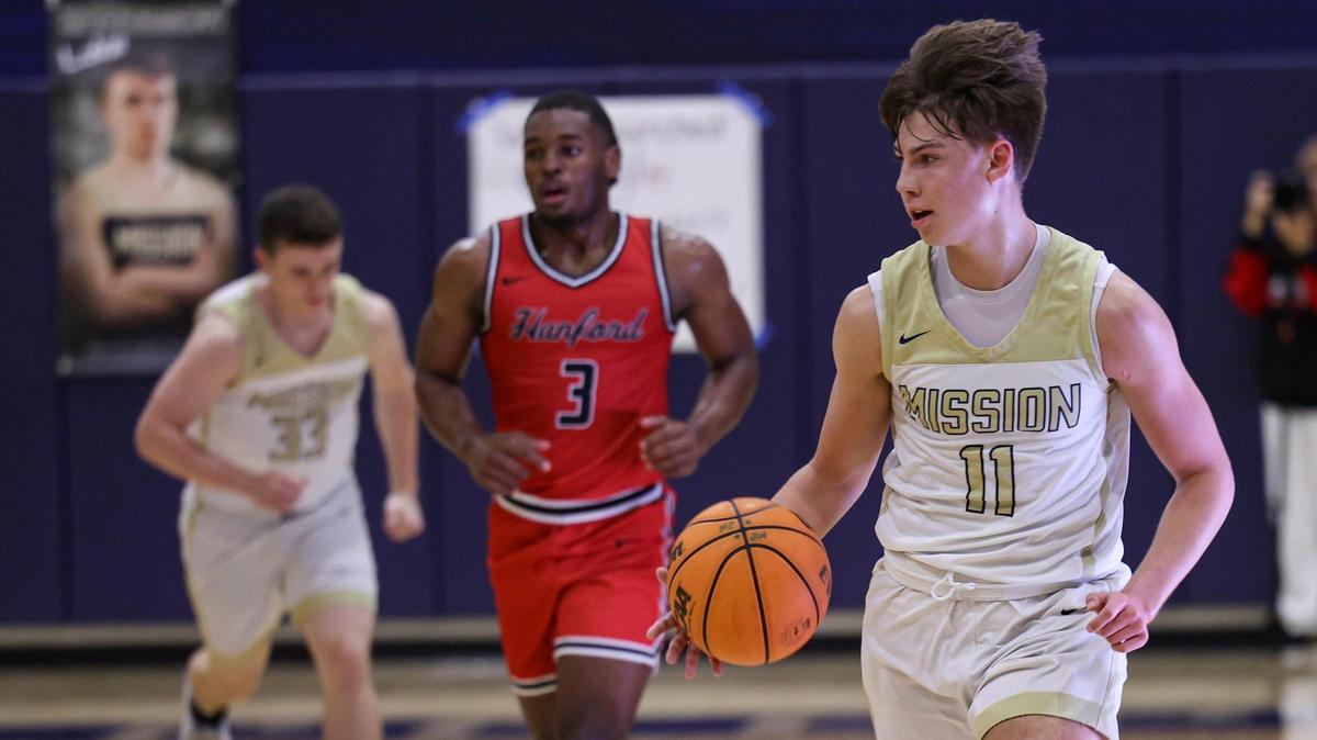 Roman Benedetti gets the ball past a trapping defense. Mission Prep won 74-48 over Hanford in a boy’s basketball playoff Feb. 13, 2024.