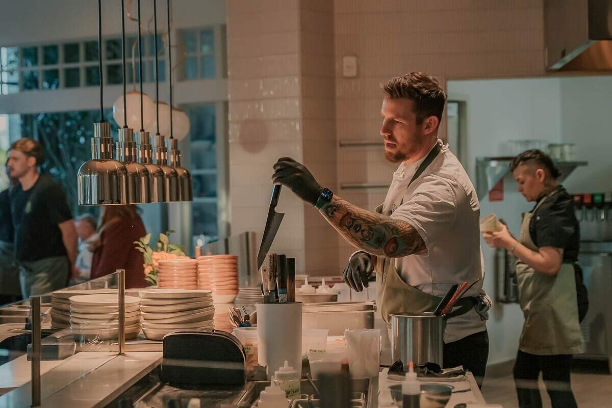 Executive Chef Casey McMinn prepares dishes at EMRÉ, where live-fire cooking and Eastern Mediterranean flavors define the restaurant’s menu.