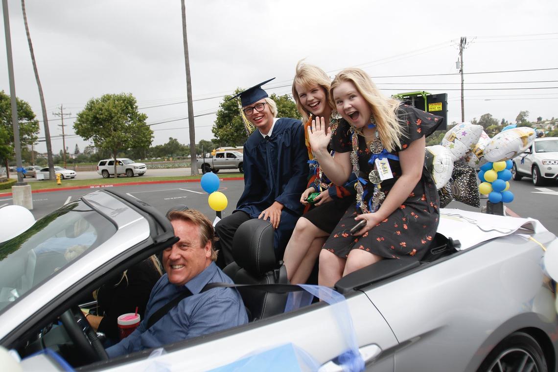 Graduating seniors from left, Tanner Price, Elle Harmon, Addison Borum ride in the back of a convertible. Arroyo Grande High School hosted its graduation ceremony in the parking lot of the South County high school, with two separate times for graduates to drive through and get their diplomas. Families showed up in a variety of vehicles, including a 1943 half-track tank.