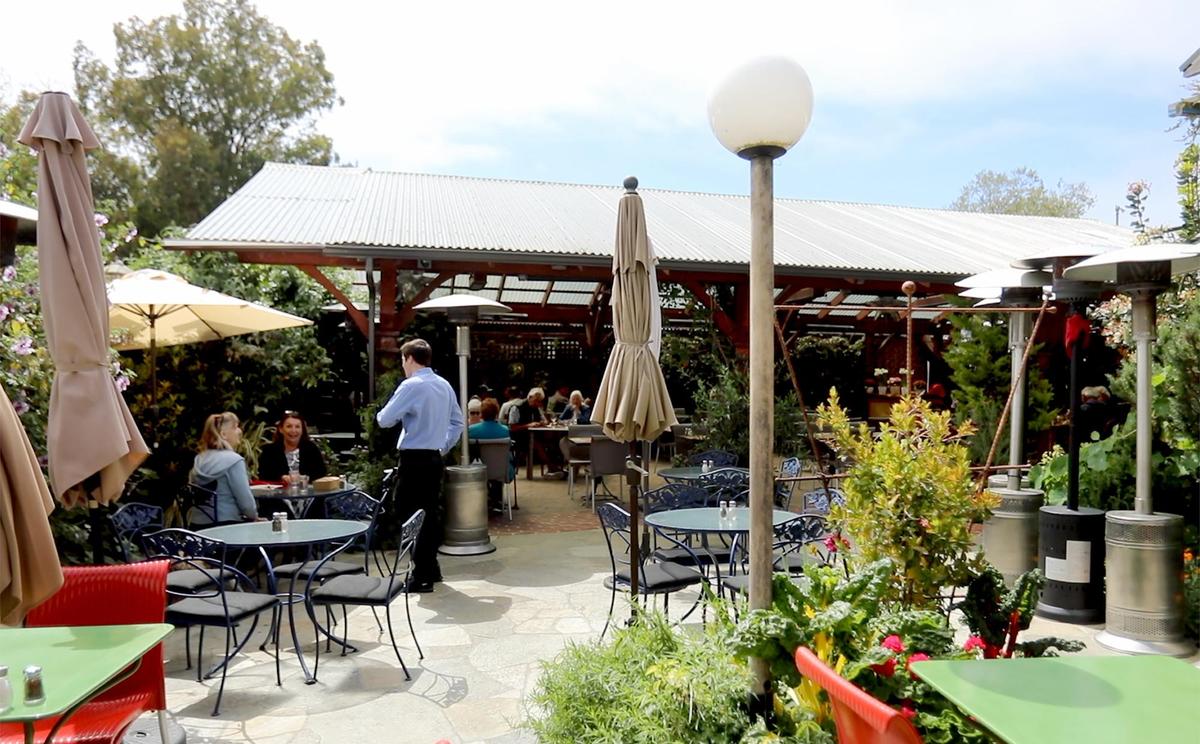 The garden patio of Robin’s restaurant in Cambria, California, is filled with plants and flowers. 