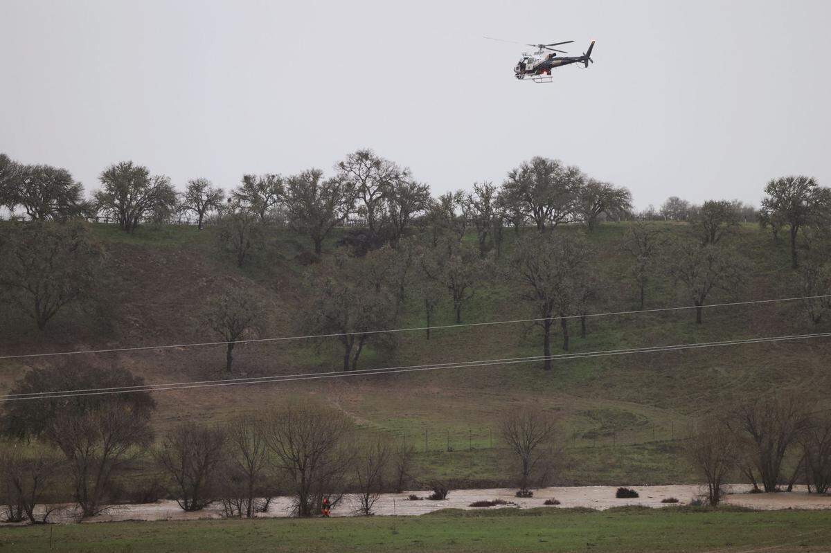 A CHP helicopter assists in a search for a child who was swept away by floodwaters from San Marcos Creek near Paso Robles after a on Monday, Jan. 9, 2023.